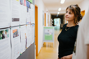 Studentin an einem Aushang mit Jobaangeboten 