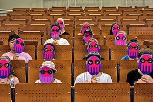 Kinder mit Masken mit dem Maskottchen der Kinderuni im Hörsaal der HTW Berlin © KUL/Dirk Lamprecht 