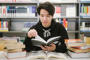 Student mit vielen Büchern © HTW Berlin/Alexander Rentsch