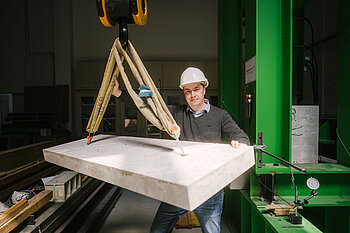 Mann vor Betonplatte am Seil