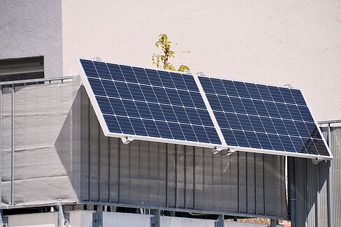 Solarmodule eines Steckersolargeräts an einem Balkongeländer.
