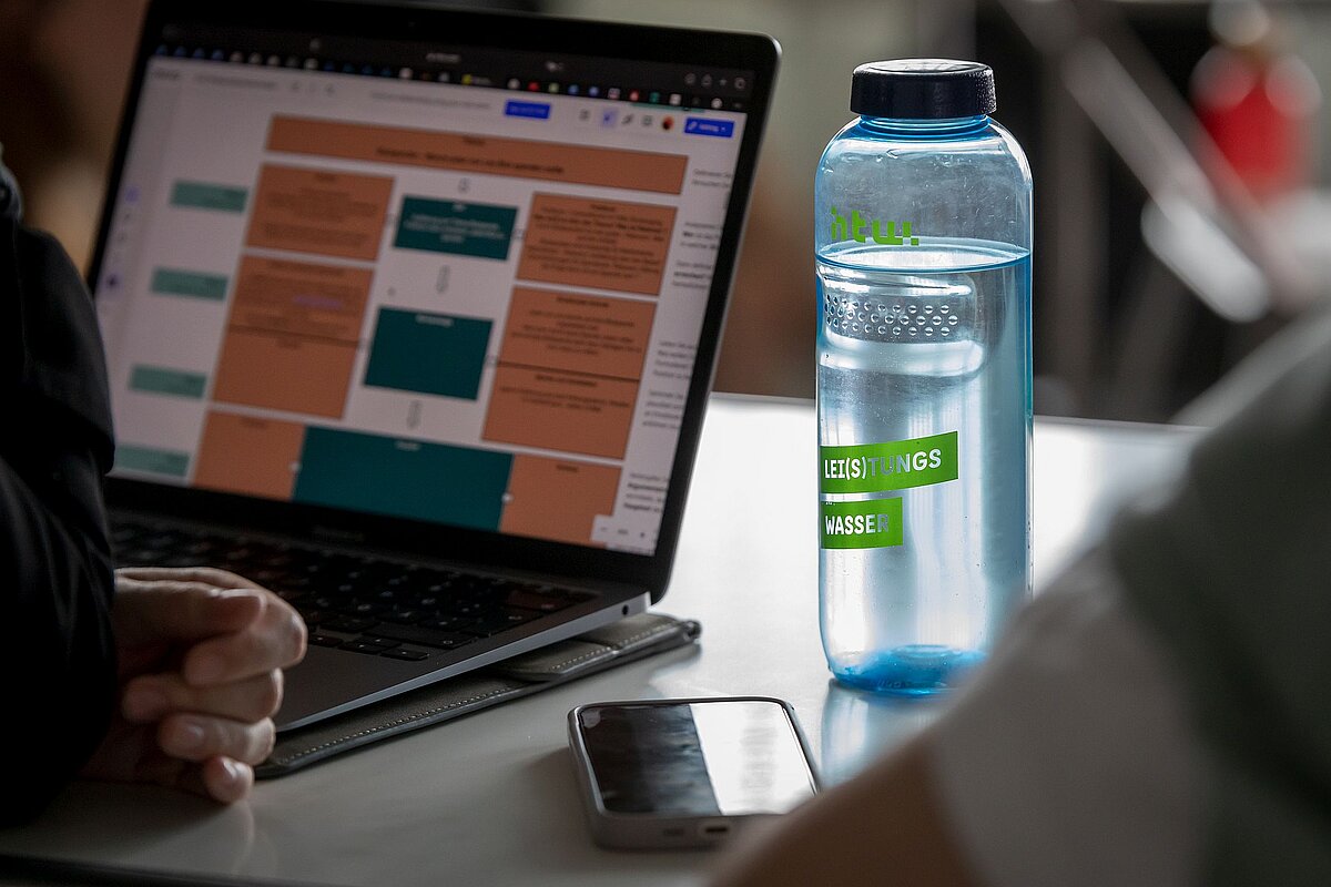 Laptop mit einer Übungsaufgabe, daneben eine HTW-Trinkflasche © HTW Berlin/Tobias Golla