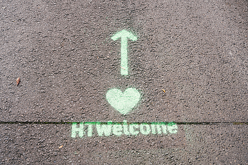 Auf Asphaltboden sind ein geradeaus-Pfeil, ein Herz und der Schriftzug HTWelcome zu sehen. © HTW Berlin